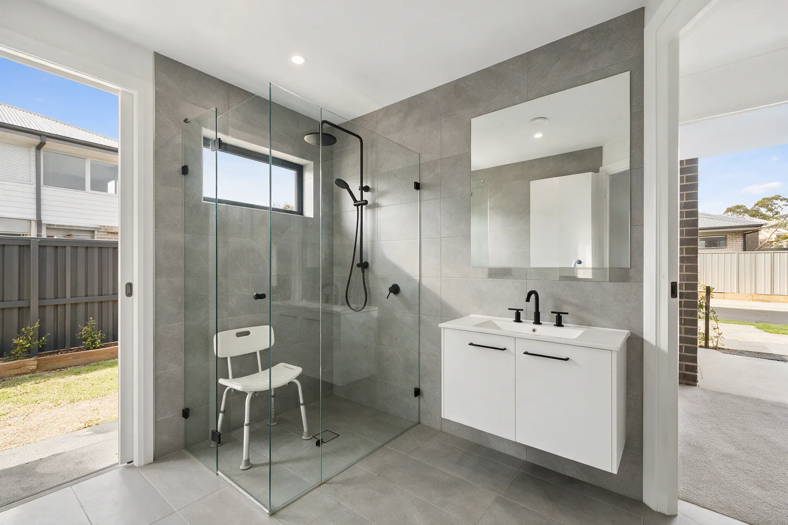 Modern Gungahlin townhouse ensuite with a shower chair in a level-entry glass shower