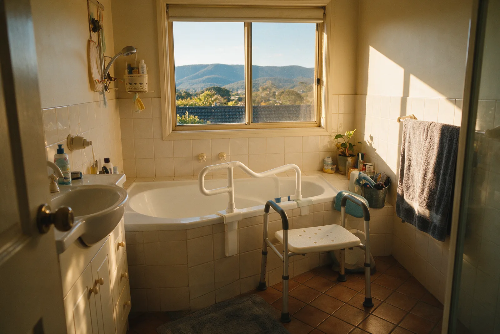 Tuggeranong family bathroom with bath rail and transfer bench and a view of the ranges